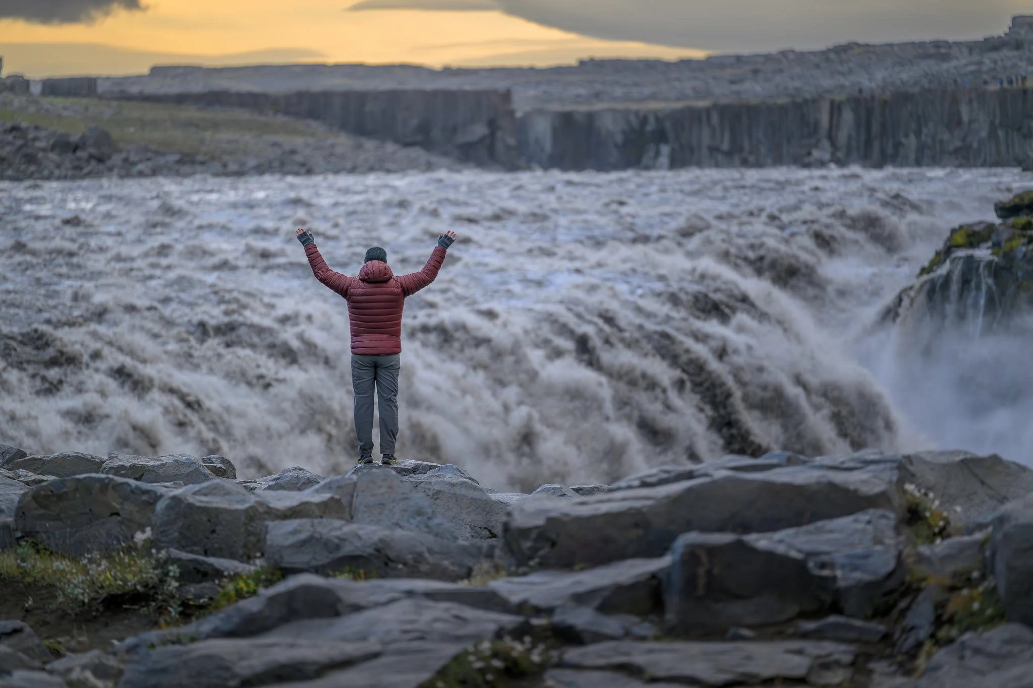 Powerful Dettifoss waterfall in Iceland thundering over basalt cliffs with moss-covered rocks and billowing mist from eastern viewpoint.